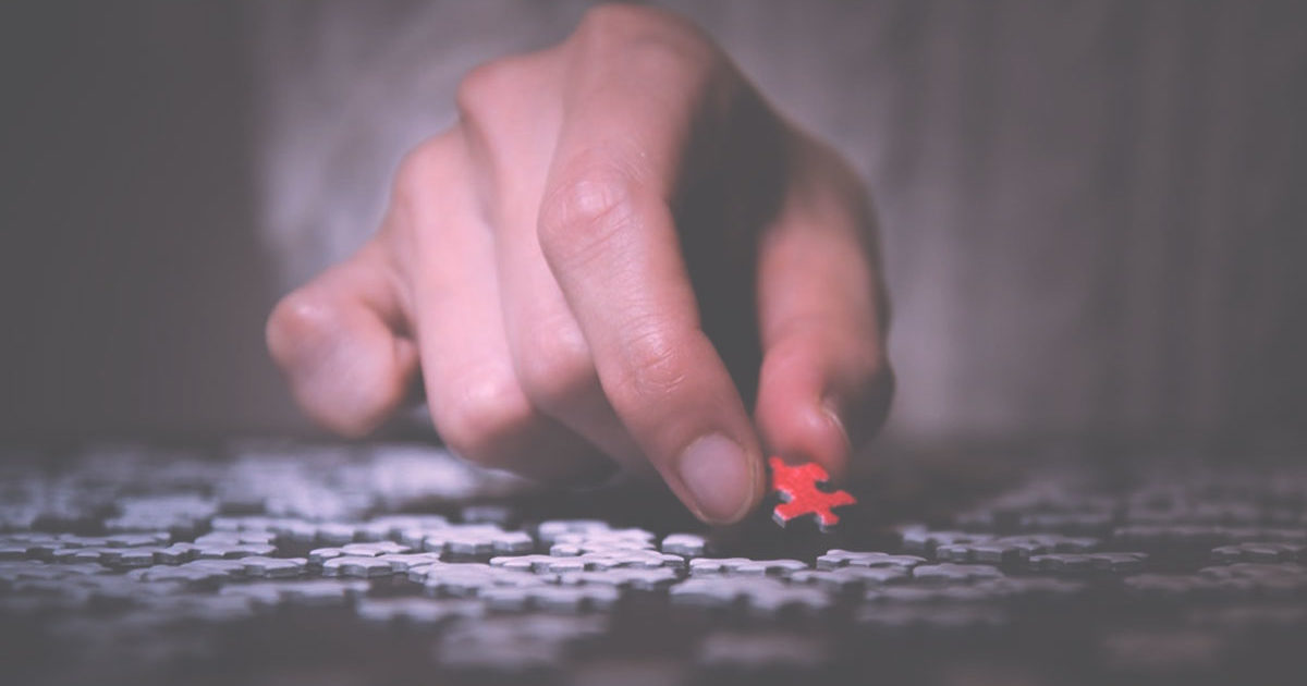 man puts puzzle piece in place a metaphor for the aha moment